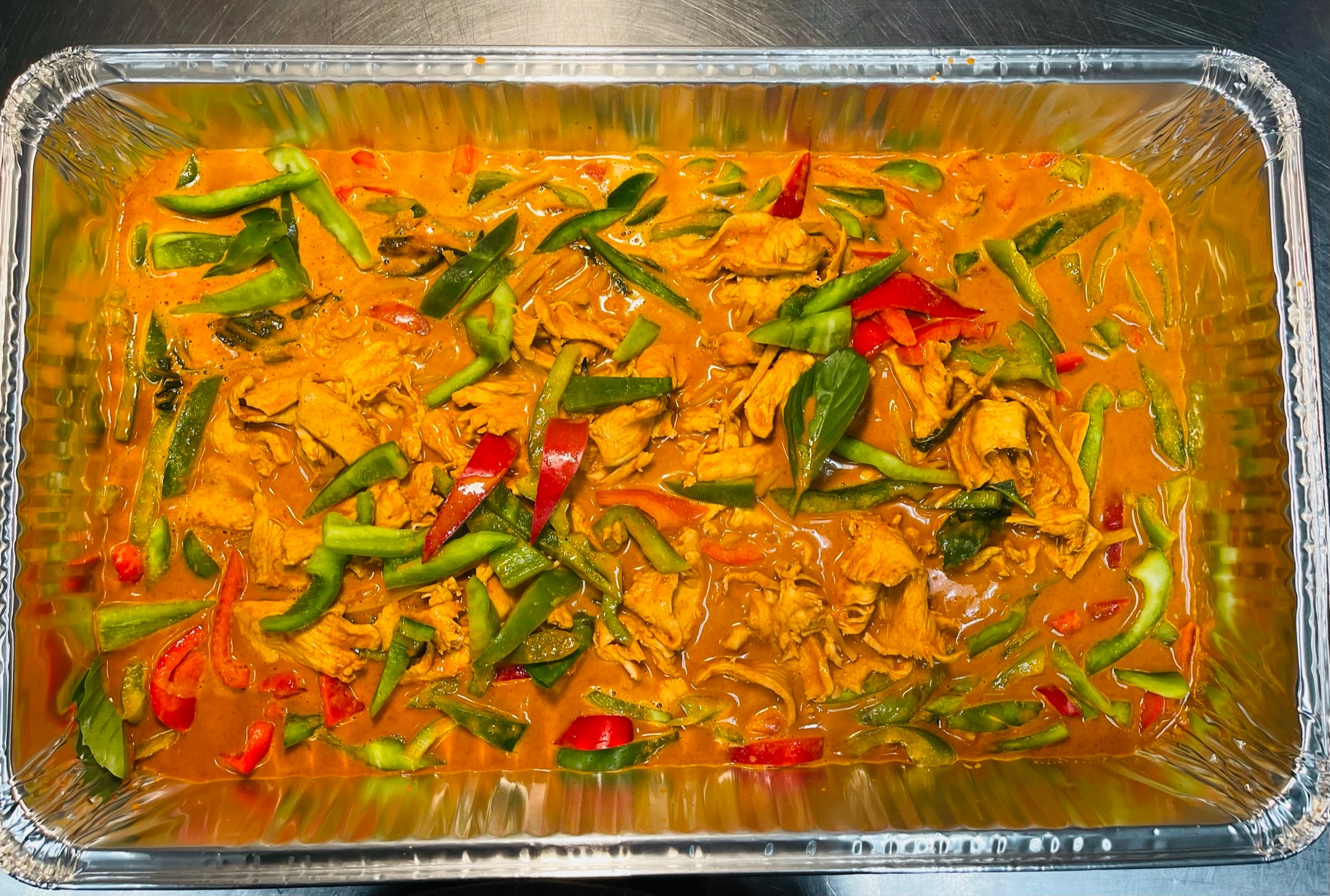Catering tray of mango sticky rice with blue butterfly pea rice, fresh mango slices, coconut cream and orchid flowers
