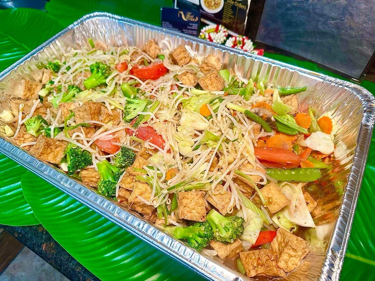 Large catering tray of mixed vegetable stir fry with tofu, broccoli, bean sprouts and snap peas