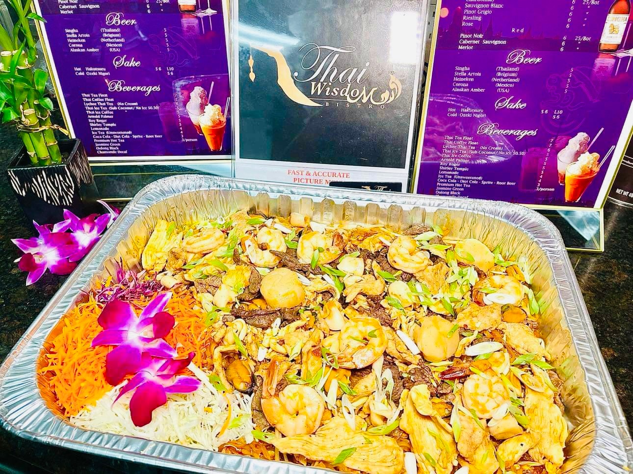 Small catering tray of Pad Thai with shrimp garnished with orchid flowers