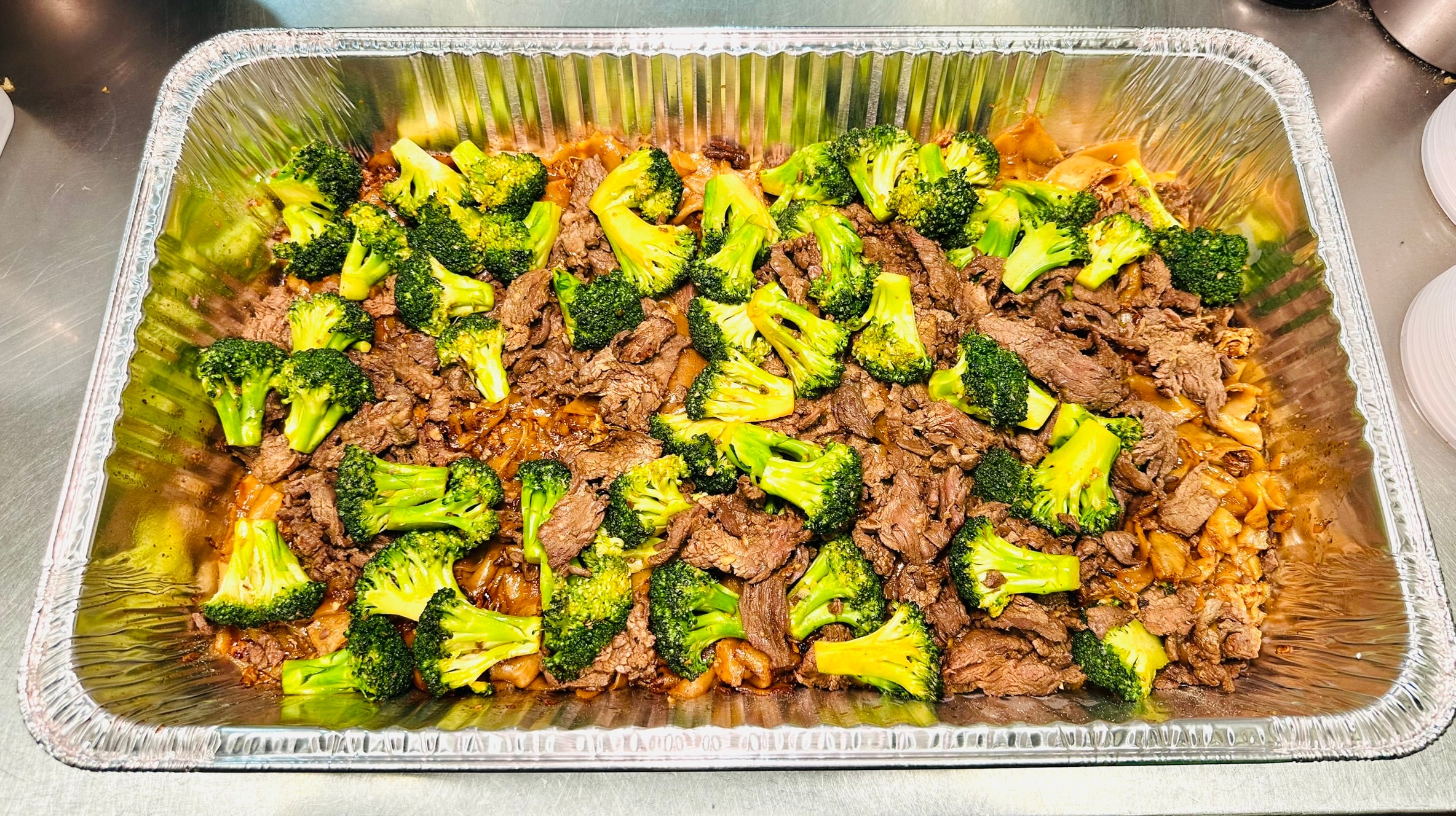 Small catering tray of Se Ew with beef and broccoli in brown sauce