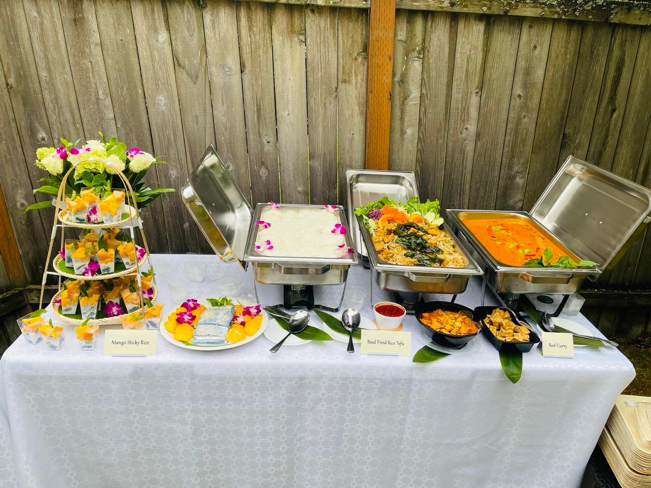 Outdoor catering event setup with Thai food display