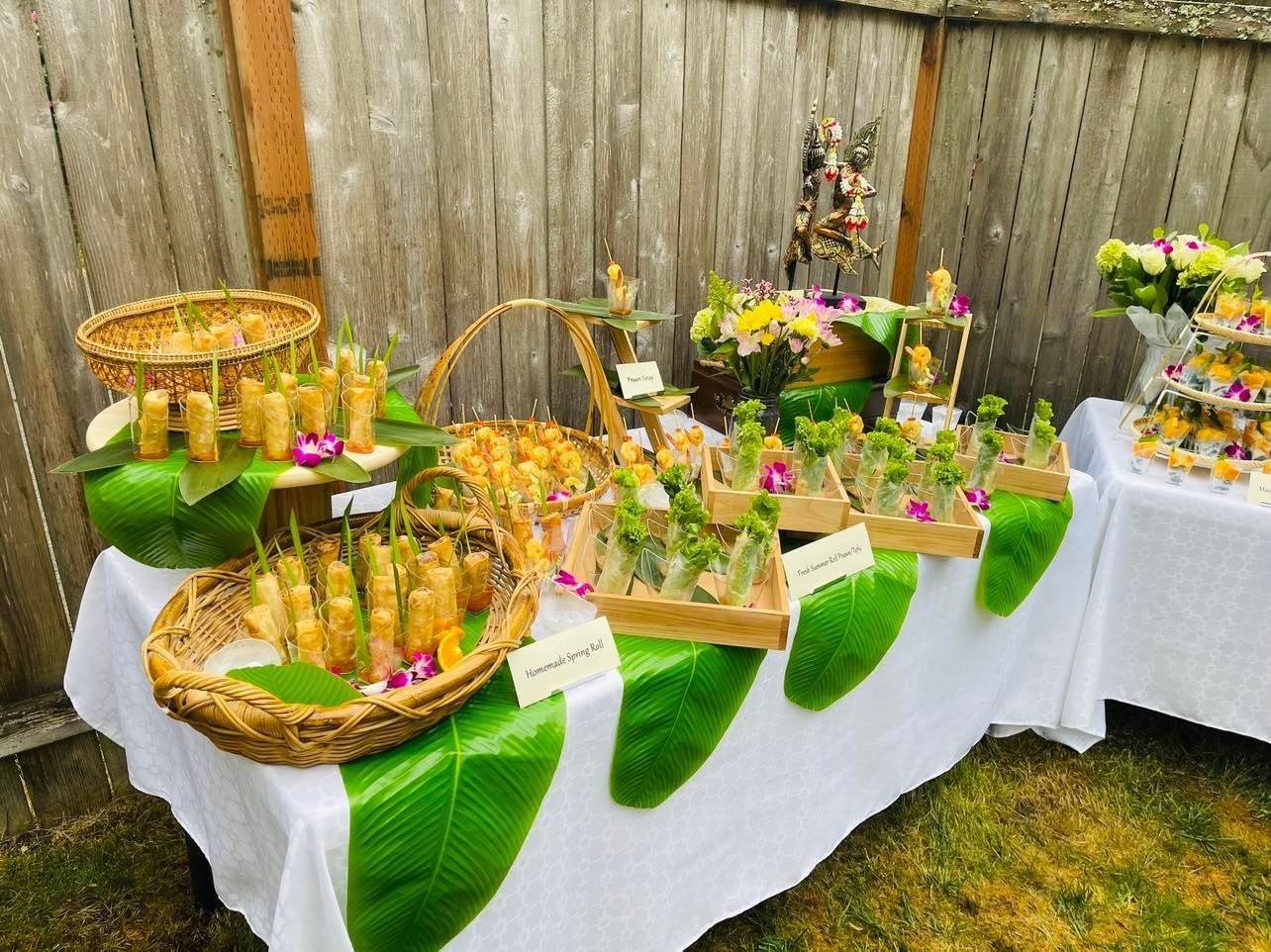 Homemade spring rolls in wicker baskets with summer rolls and prawn satay