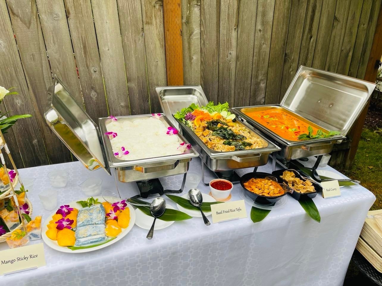 Mango sticky rice, basil fried rice tofu and red curry chafing dishes close up
